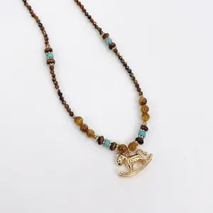 Golden rocking horse pendant necklace with brown tiger eye beads and turquoise accents