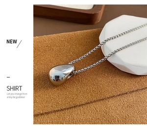 Detail of silver waterdrop pendant with high-polished finish on a box chain necklace