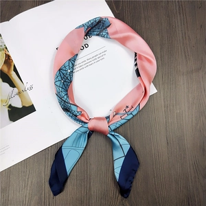 Detailed close-up of pink and blue square silk scarf with geometric architectural prints