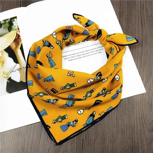 Yellow Alice in Wonderland print square scarf displayed on a magazine and wood table