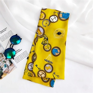 Detail of yellow silk scarf featuring astrological zodiac patterns and celestial icons