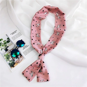 Detail of light pink silk scarf with black polka dots and dalmatian prints on a magazine