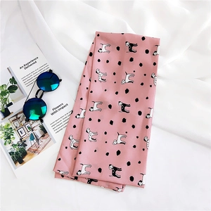 Detail of pink silk scarf with dalmatian print and dots on a white background