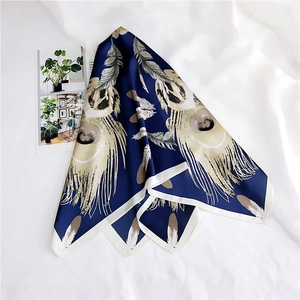 Detail of silk square scarf featuring elegant feather prints and navy blue finish