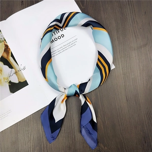 Detail of blue and yellow geometric silk scarf tied in a loop on a fashion magazine