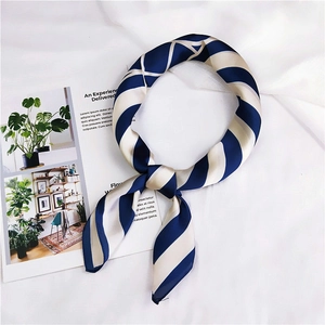 Detail of blue and white striped silk satin square scarf tied in a stylish knot