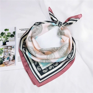 Détail d'un élégant foulard en soie à motif paisley rose et noir avec texture satinée