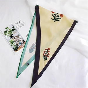 Close-up of floral print silk scarf with tricolor contrast border on white fabric
