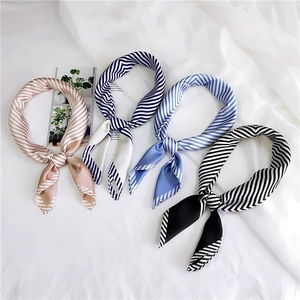 Detail of four colorful striped silk square scarves in champagne blue and black styles