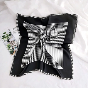 Detail of a black and white striped silk scarf folded in a stylish radial pattern