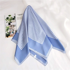 Detail of blue and white striped silk scarf with a glossy finish on white fabric