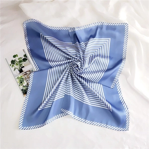 Detailed view of blue and white striped silk scarf with satin texture on white fabric