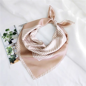 Detail of elegant striped champagne silk square scarf with glossy finish and soft drape