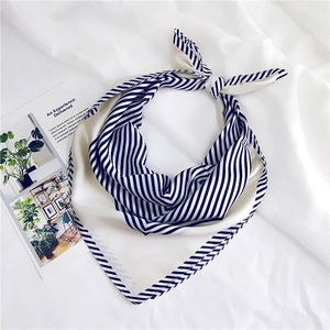 Close-up of a navy and white striped satin square scarf with a neat decorative knot