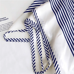 Detail of white striped silk scarf with navy nautical pattern and soft fabric texture