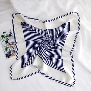 Detail of white square silk scarf with navy blue stripes in a spiral layout