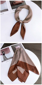 Detailed view of a brown and white striped satin square scarf styled on a wooden table