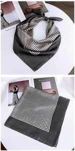 Detail view of a striped square silk scarf with dark gray and beige V-shaped patterns