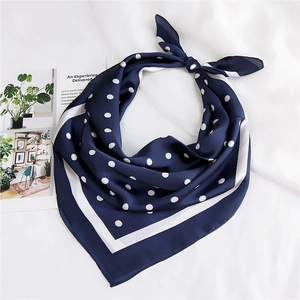 Détail d'un foulard en soie bleu marine à pois avec bordure blanche contrastée