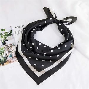 Détail d'un foulard en soie à pois noirs et blancs noué en un élégant nœud décoratif