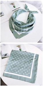 Détail d'un foulard en soie vert menthe à pois montrant l'aspect plié et plat