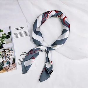 Detail of silk square scarf with red artistic letters and grey stripes on white fabric