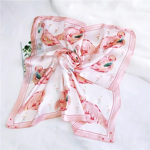 Detail of pink silk-like square scarf with elegant flamingo print and star border