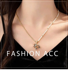 Detail of zebra enamel pendant necklace featuring white pearls and golden link chain