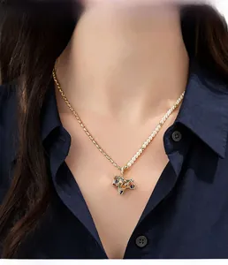 Detail view of a half-pearl half-gold chain necklace with a colorful horse pendant