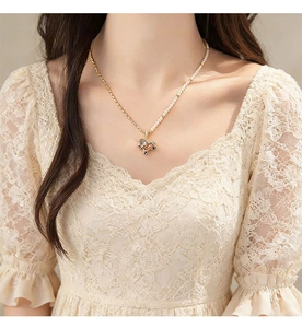 Detail of elegant pearl and gold chain necklace with colorful pony pendant