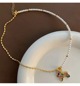 Macro view of a colorful pony pendant necklace with pearls and gold wavy chain links