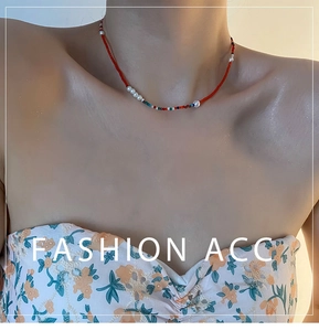 Détail du collier de perles rouges et perles d'eau douce sur le cou du mannequin