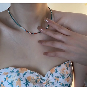 Gros plan d'un collier de perles bohème avec perles d'eau douce sur femme