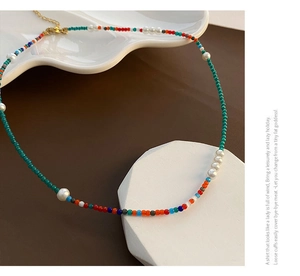 Gros plan d'un collier de perles colorées avec perles d'eau douce et fermoir en métal doré