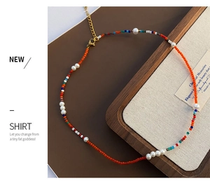 Détail d'un collier bohème avec perles colorées, perles d'eau douce et fermoir doré