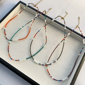 Colliers de perles colorées avec perles d'eau douce et fermoirs dorés sur un plateau bijoux