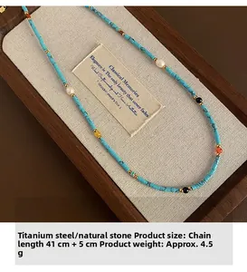 Detail of beaded turquoise and agate necklace in wooden jewelry box with fabric lining