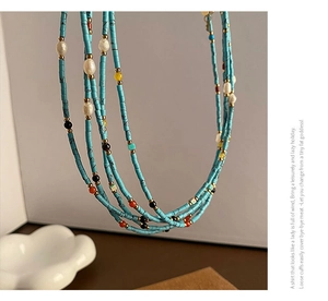 Close-up of bohemian layered necklace with turquoise beads and freshwater pearls