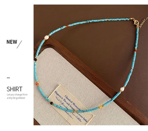 Detailed shot of handmade beaded necklace with turquoise cylinders and lobster clasp
