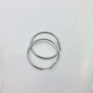 Gros plan détaillé de boucles d'oreilles créoles classiques en acier titane argenté