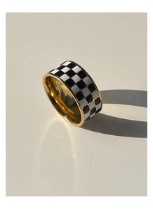 Macro shot of 18K gold plated stainless steel ring with black and white checkerboard pattern
