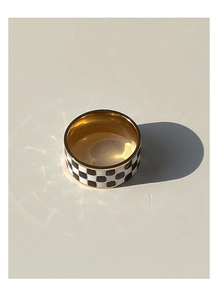 Macro detail of 18K gold titanium steel ring with black and white checkerboard pattern