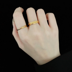 Detail of 18K gold-plated rings showing polished and matte finishes on a hand