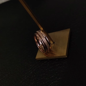 Close-up of three rose gold titanium steel rings with matte and polished textures