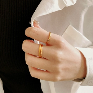 Close-up of minimalist gold plated titanium steel rings with stacked layers on hand