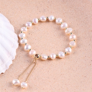 Detalle de pulsera de perlas barrocas de agua dulce con cuentas doradas y cierre ajustable