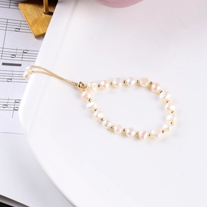 Detalle de pulsera de perlas barrocas de agua dulce con cadena dorada ajustable en bandeja