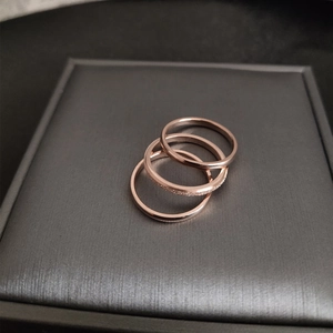 Three-piece set of minimalist 18K rose gold stackable rings with smooth and frosted finishes