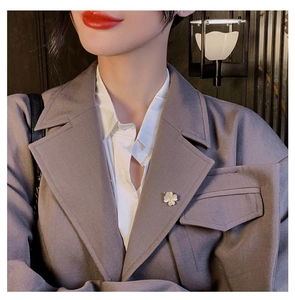 Élégante broche fleur à cinq pétales en zircon avec pétales opale sur blazer gris
