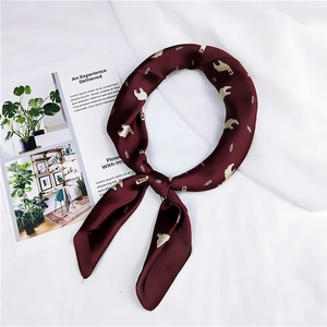 Détail macro du foulard en soie bordeaux avec motif ours polaire et plumes blanches